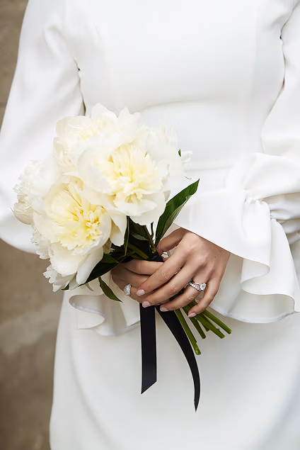 Bride holding a white peony flower bouquet, detail shot